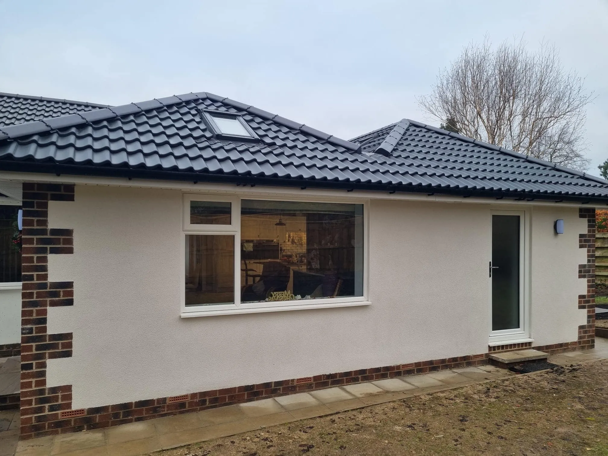 A white house with a black tiled roof.