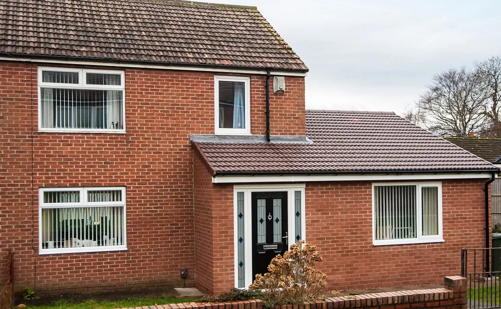 A red brick house with a black front door.