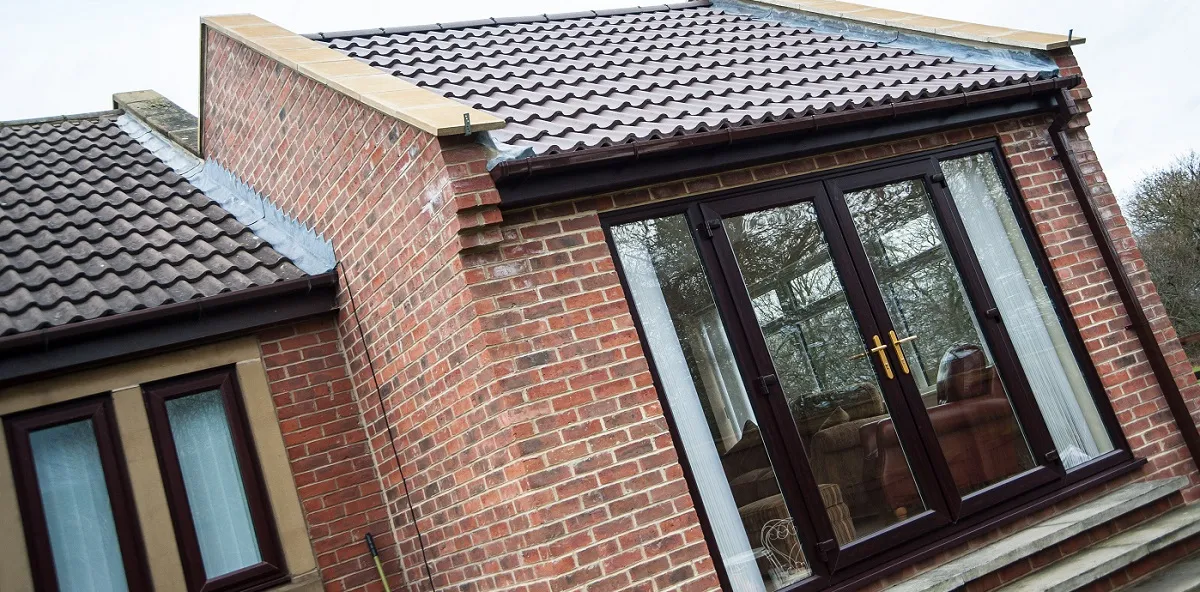 A brick house with a tiled roof and windows.