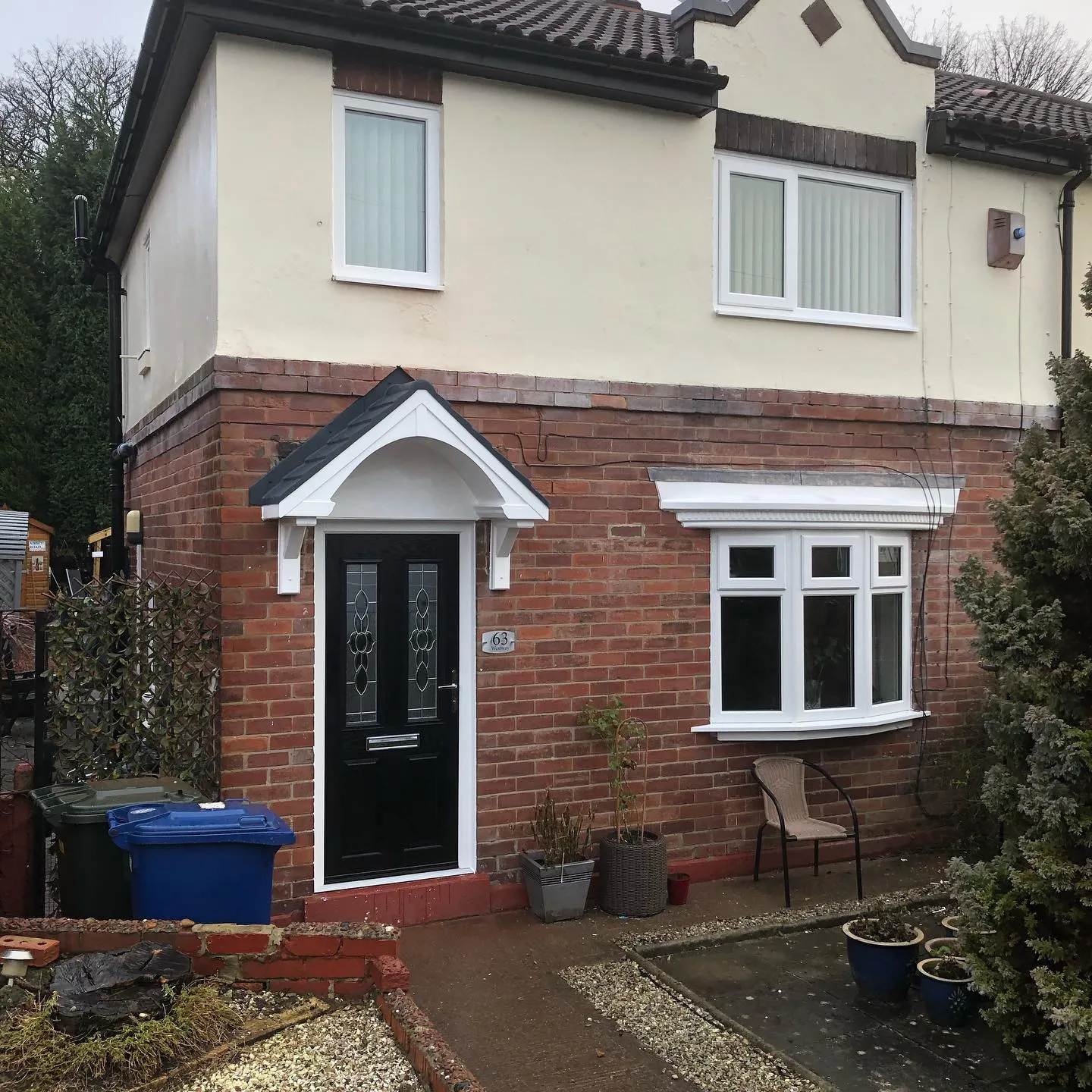 A brick house with a black door and windows.